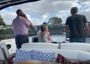 Three people on a river boat looking out at what's ahead of them